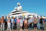 Teilnehmer der Lenkungsgruppe stehen vor der Yacht "Pelorus"